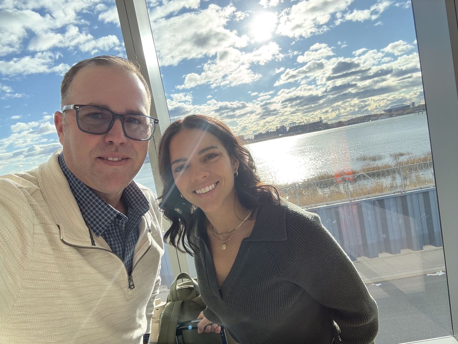 Two members of the Cognition team in front of a sunlit waterfront window.